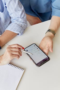 People Holding Cellphone and a Pen