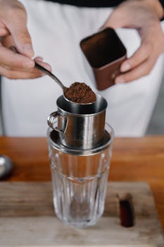 Person Holding Stainless Steel Cup With Brown Powder